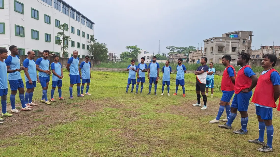 A course cohort with their coach educators on the ground.